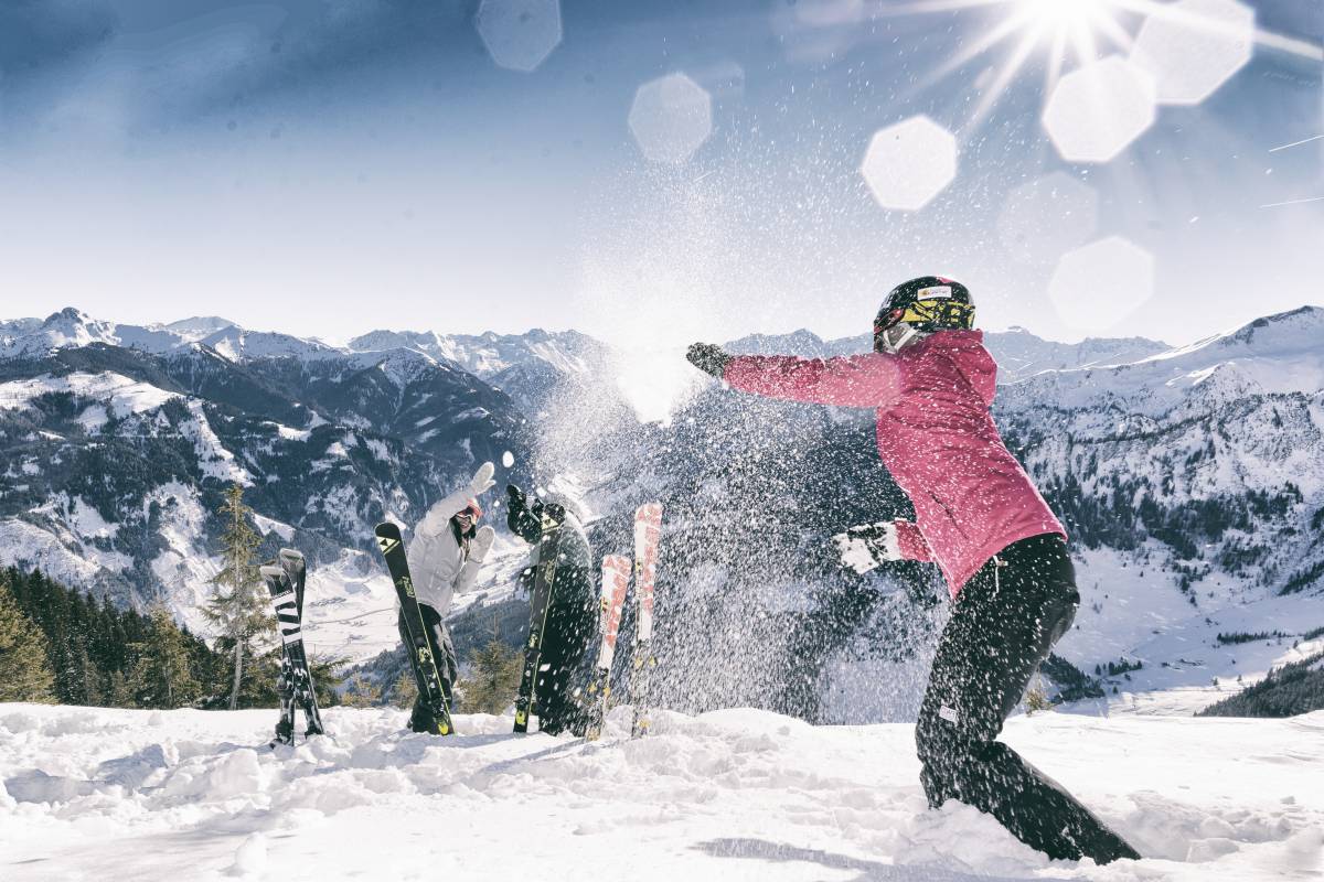 Freunde bei Schneeballschlacht in den Bergen in Österreich