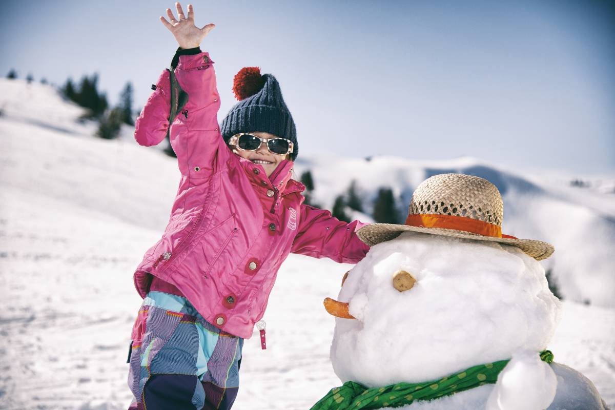 Kind beim Schneemann bauen